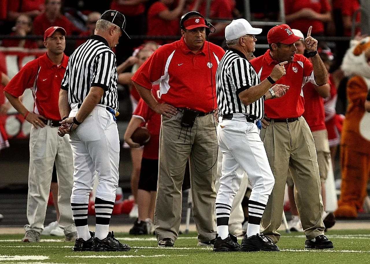 high school football, confrontation, football coach, referee, disagreement, argument, discussion, sports official, talking, argue, dispute, male, man, conflict, meeting, conversation, communication, quarrel, angry, team, relationship, coaches, football field, game, sport, body language, uncomfortable, standing, texas, stripes, striped, ruling, football coach, football coach, football coach, disagreement, argument, argue, body language, body language, body language, body language, body language. Authority at work: a script for objecting to a senior decision