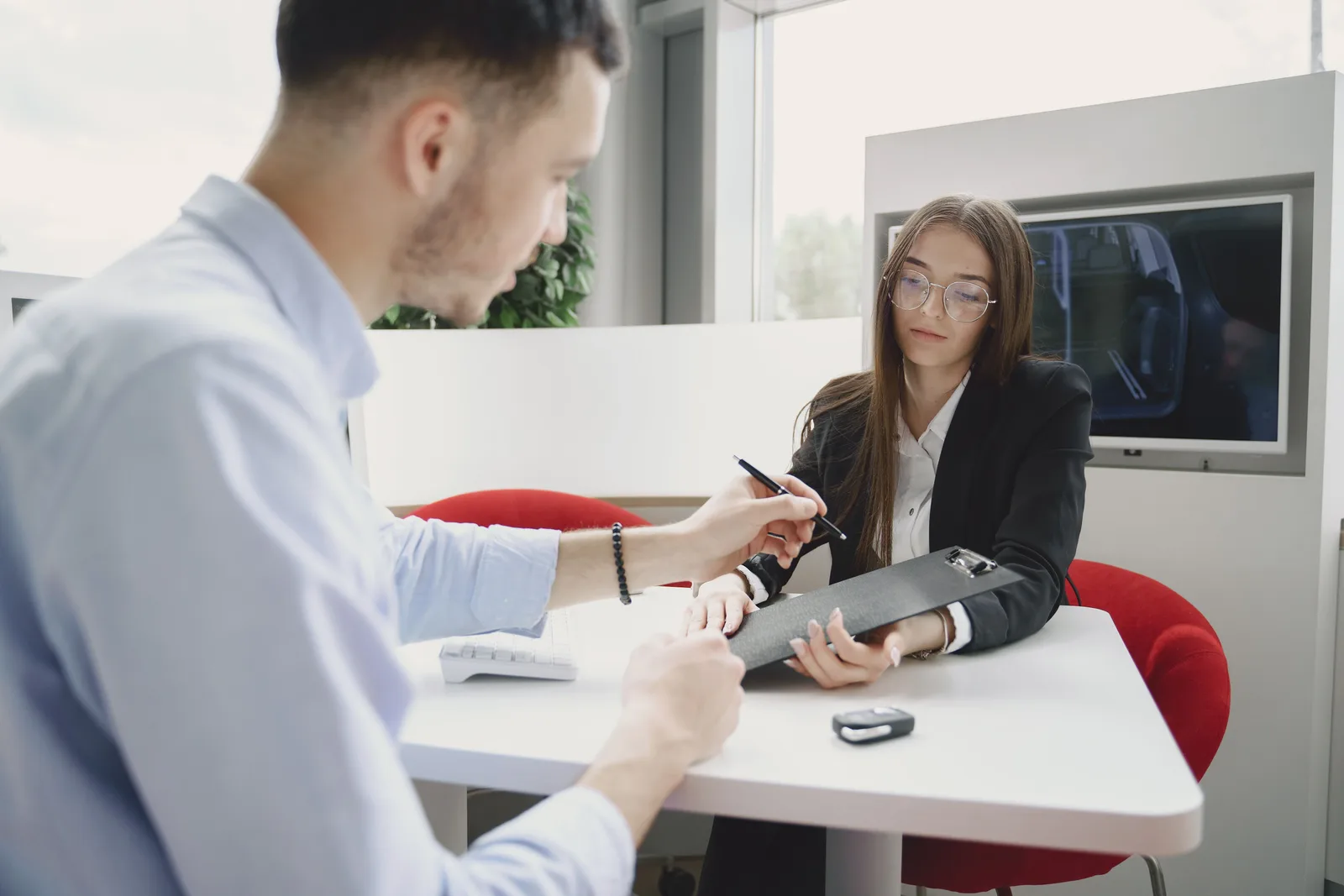 A man and woman discussing and signing a document at a table in an office setting. Ethical Persuasion Checklist: 5 Questions for US Sales Teams