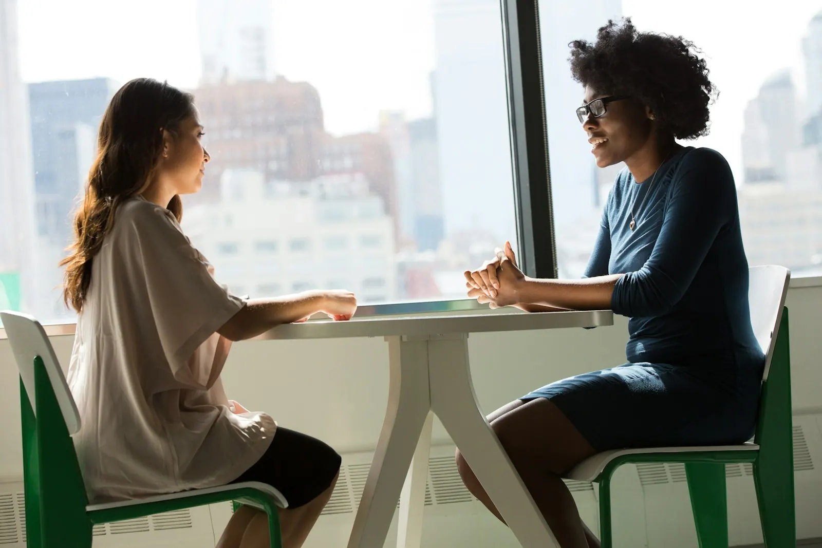 two women sitting beside table and talking. How to tell which reciprocity technique is being used on you
