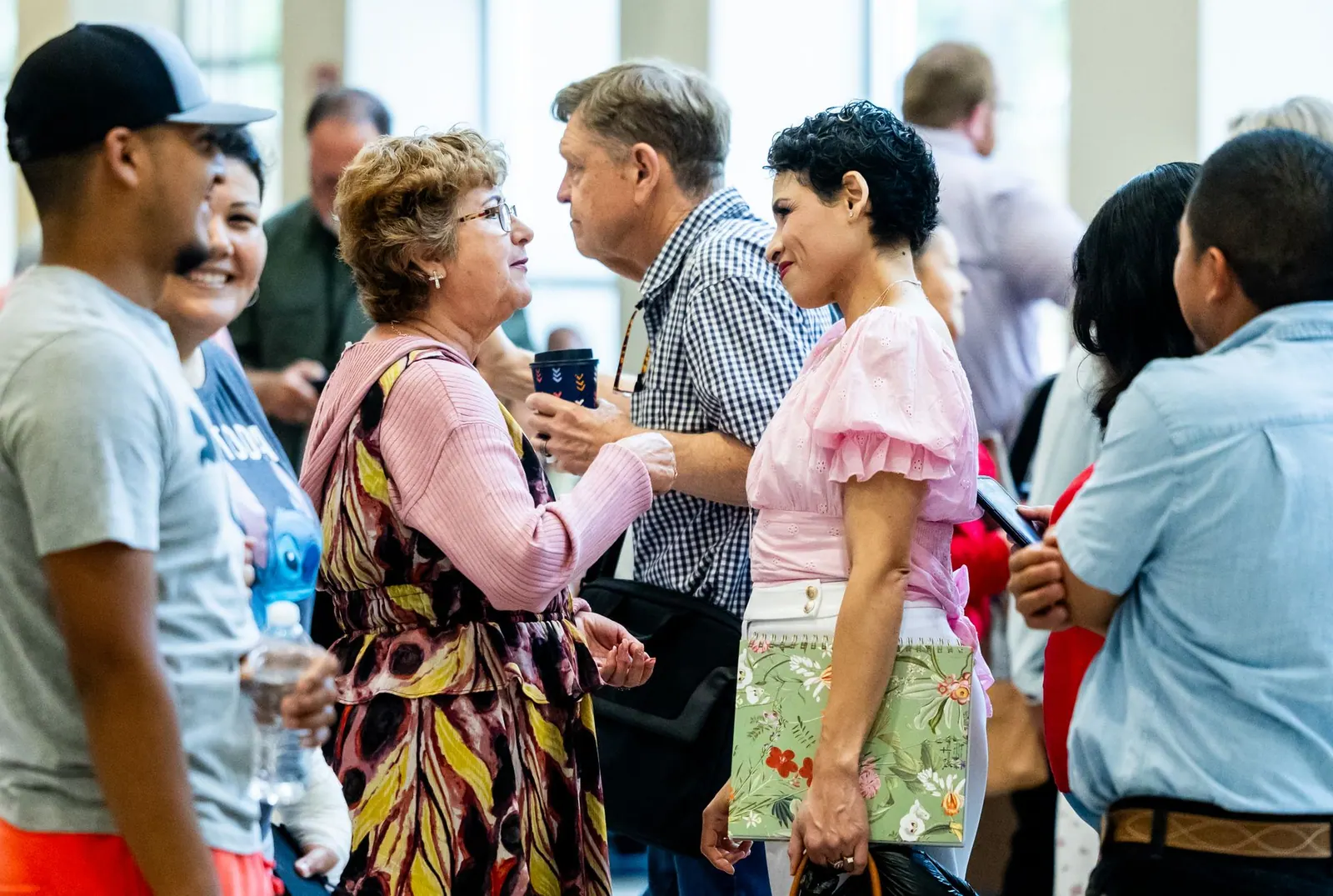 A diverse group of people engaging in conversation at an indoor gathering. Social proof ethics: responsible use and warning signs